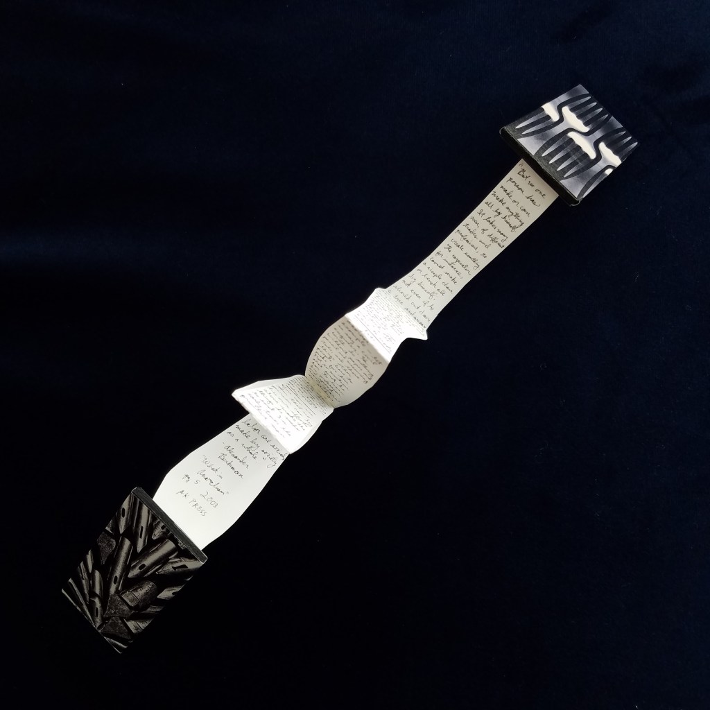 accordion book is laid open, showing the reverse side, small text.