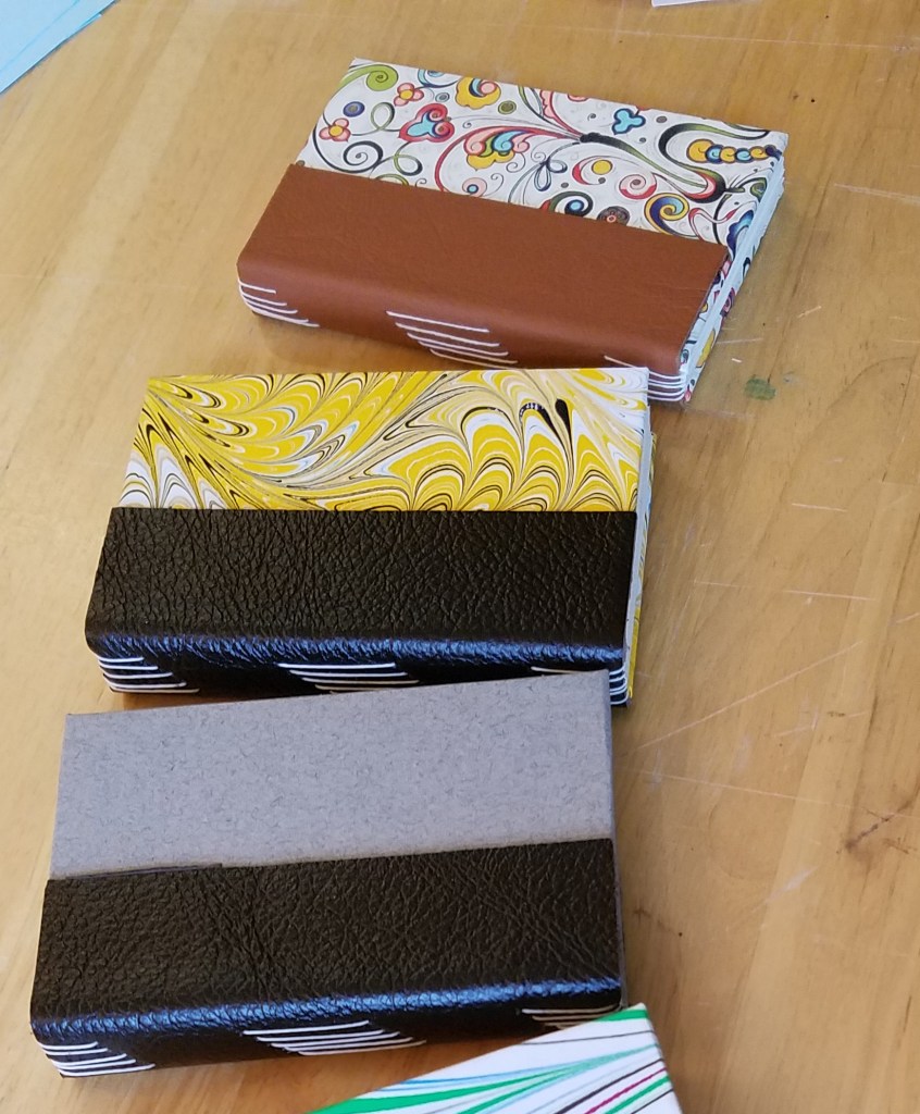 Five small books sit on a table