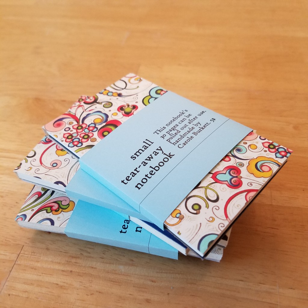 Stack of tear-away notebooks sits on table.